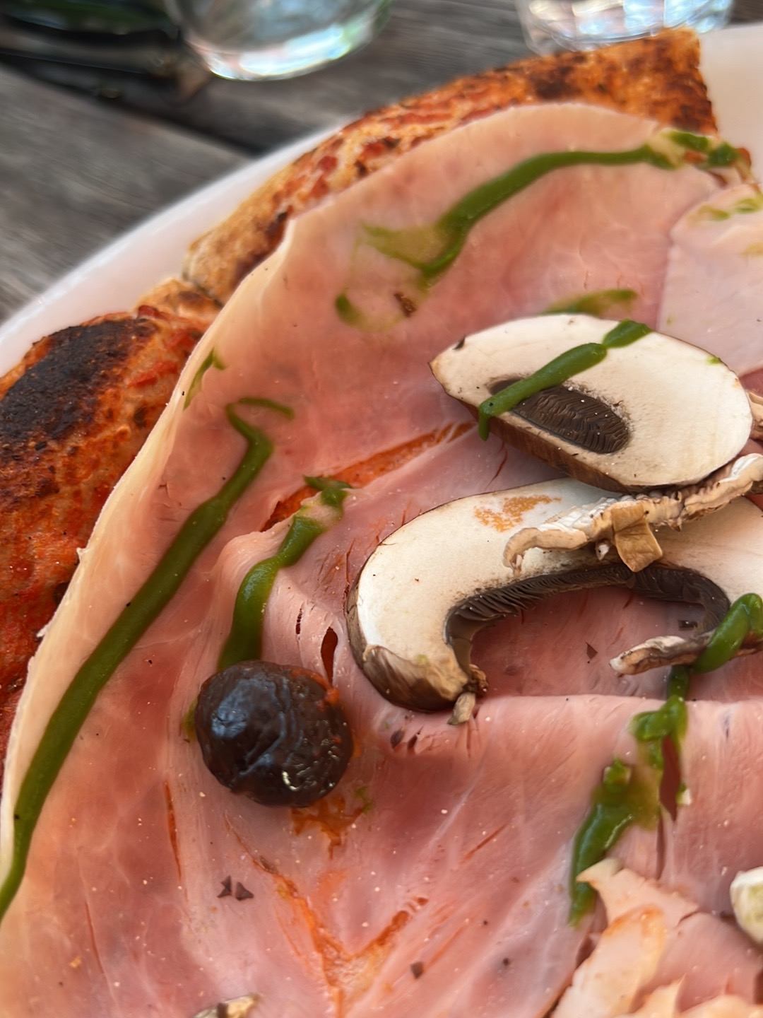 Gros plan sur une pizza au jambon, champignons et persillade