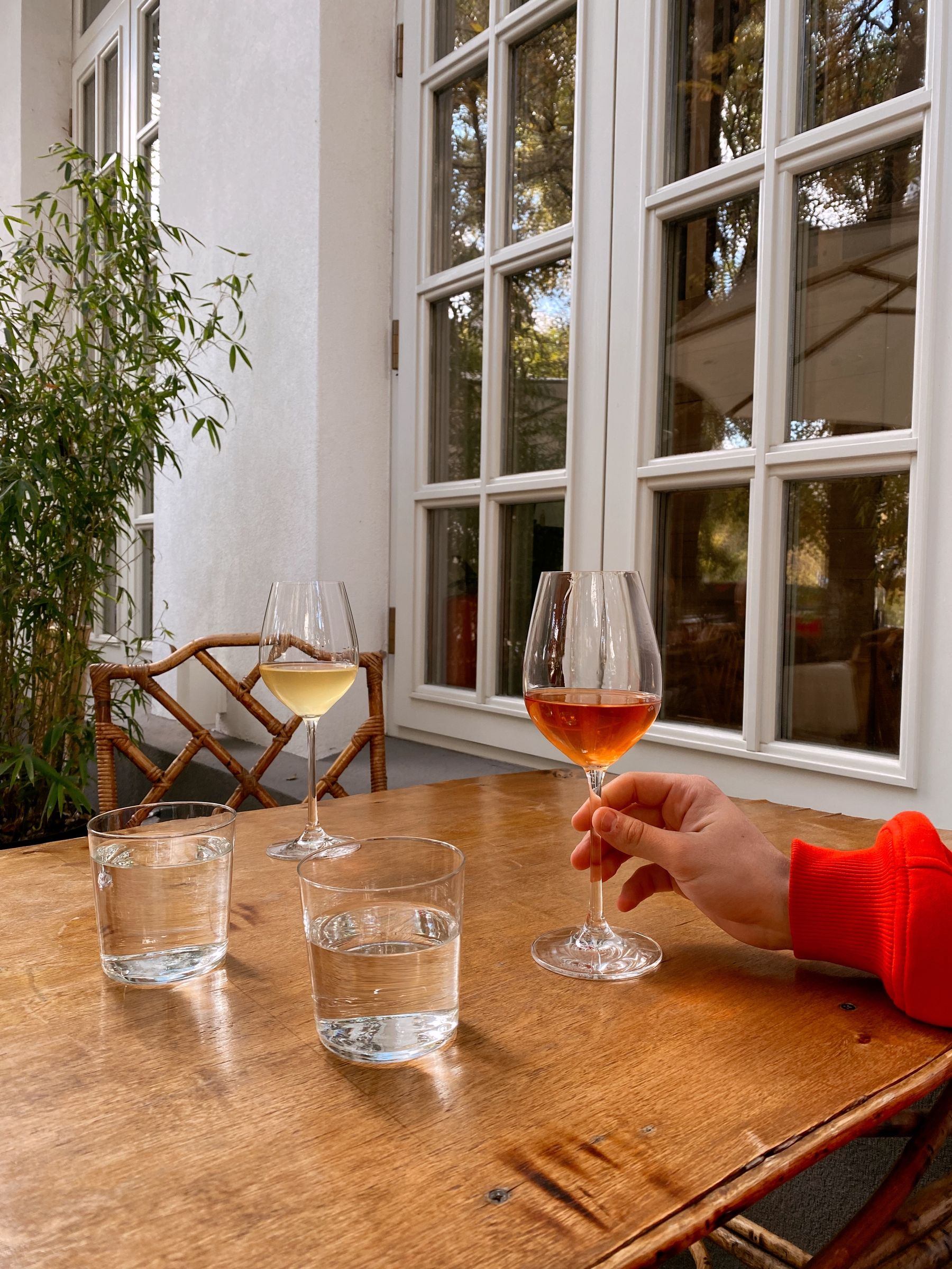 Table en bois, verres de vin et d’eau, lumière douce